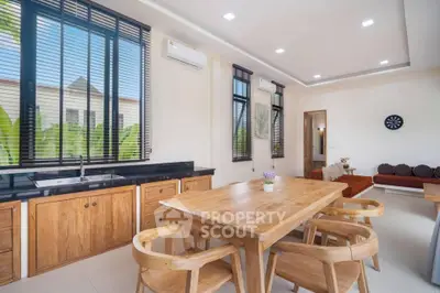 Spacious open-plan living and dining area with modern wooden furniture and large windows.