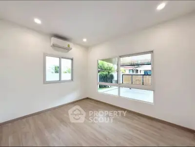 Spacious and bright living room with large windows and modern flooring