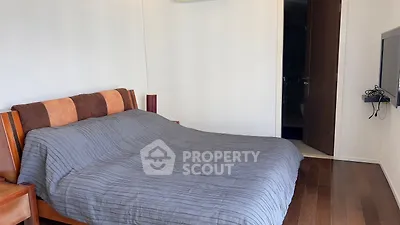 Spacious bedroom with wooden flooring and modern decor