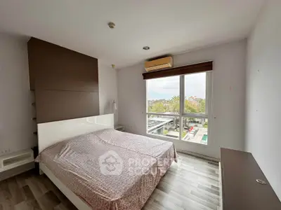 Spacious bedroom with large window offering a scenic view, featuring modern decor and ample natural light.