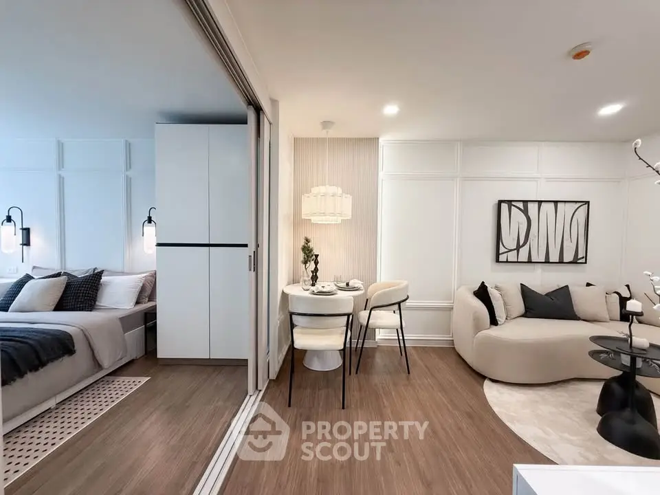 Modern open-plan living room with cozy seating and dining area, featuring elegant decor and soft lighting.