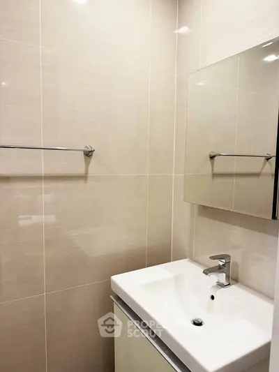 Modern bathroom with sleek sink and mirror in a minimalist design.