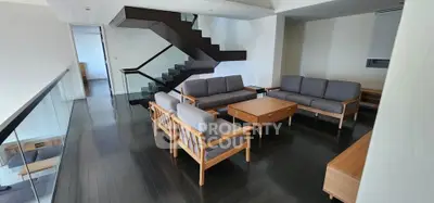 Spacious modern living room with sleek staircase and stylish wooden furniture