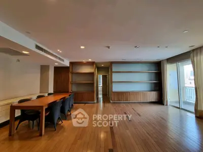 Spacious living room with wooden flooring and built-in shelves, perfect for modern living.