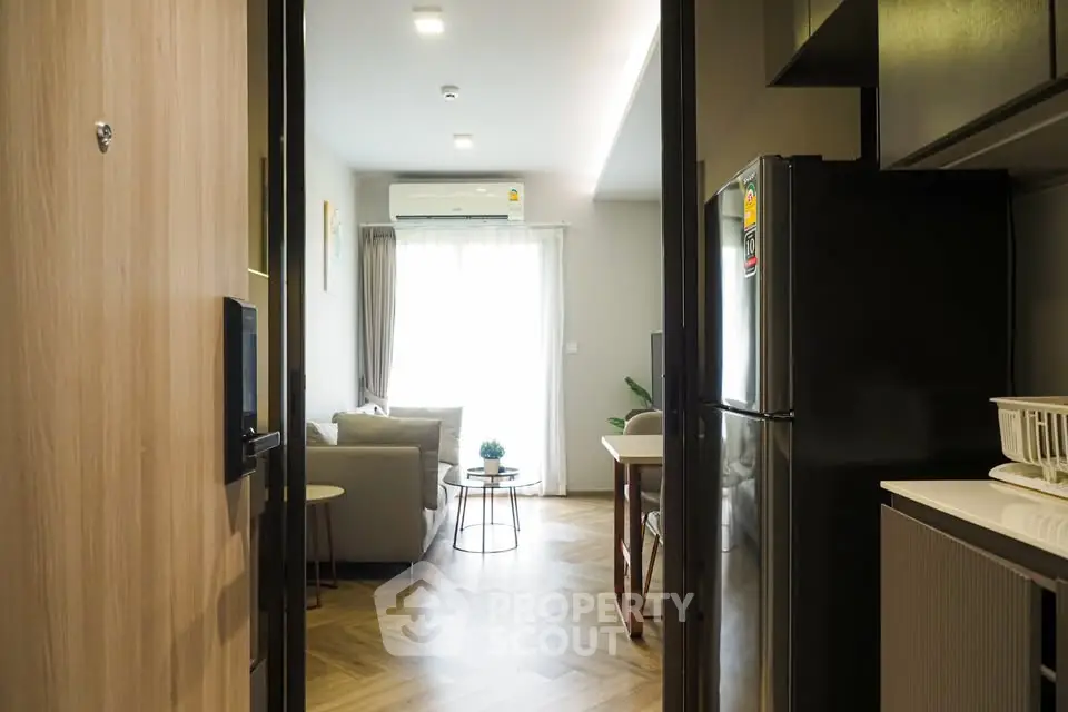 Modern apartment interior with open layout, featuring cozy living room and sleek kitchen.