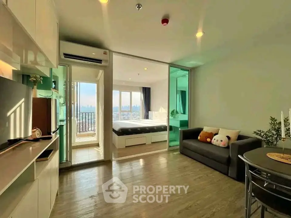 Modern open-plan living room with balcony and city view, featuring cozy sofa and stylish decor.