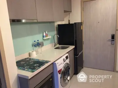 Compact modern kitchen with washing machine and sleek cabinetry