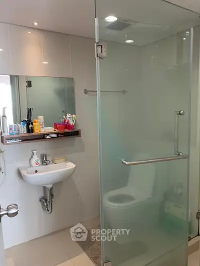 Modern bathroom with glass shower and sleek fixtures in a contemporary apartment.