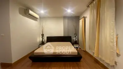 Spacious bedroom with modern decor and wooden flooring