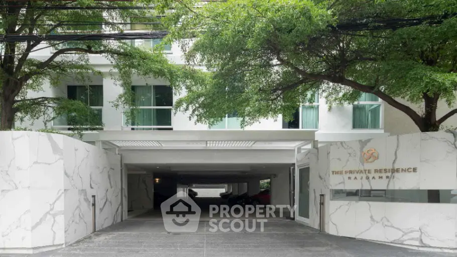 Elegant entrance of The Private Residence Rajadamri with lush greenery and modern design.