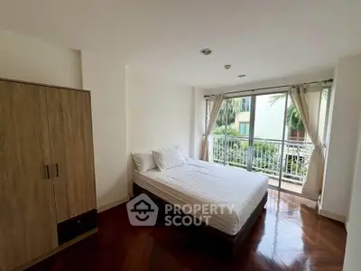 Spacious bedroom with large window and balcony access in modern apartment