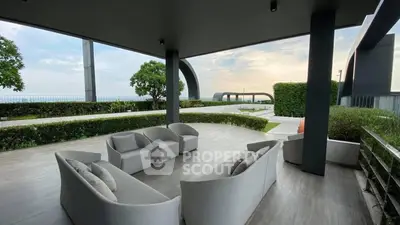 Luxurious outdoor patio with modern seating and ocean view, perfect for relaxation.