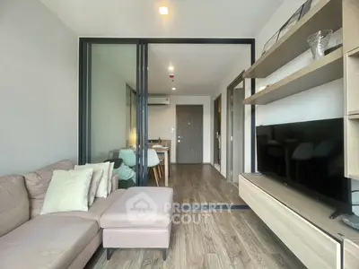 Modern living room with sleek design and open layout, featuring a cozy sofa and large TV unit.