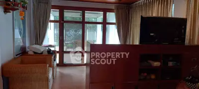 Spacious living room with large windows and cozy seating area, perfect for relaxation and entertainment.