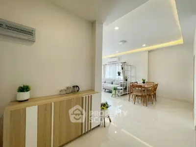 Modern open-plan living and dining area with sleek furniture and bright lighting.