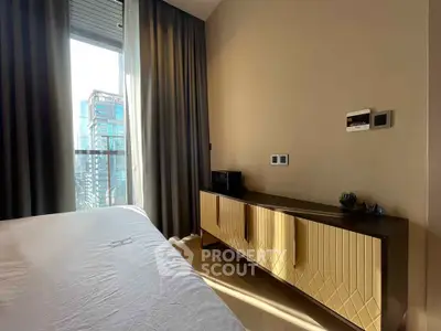 Modern bedroom with city view, stylish furniture, and natural light