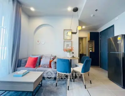 Modern living room with stylish decor and open kitchen layout, featuring cozy seating and elegant lighting.