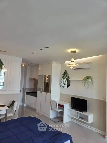 Modern studio apartment with stylish decor and open layout, featuring a cozy living area and compact kitchen.