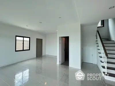 Spacious modern living room with sleek staircase and natural light