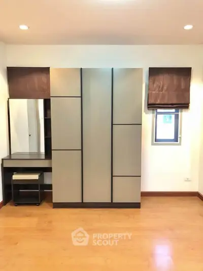 Modern bedroom with sleek wardrobe and vanity set on wooden flooring