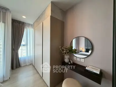 Stylish bedroom with modern vanity and large windows offering natural light.