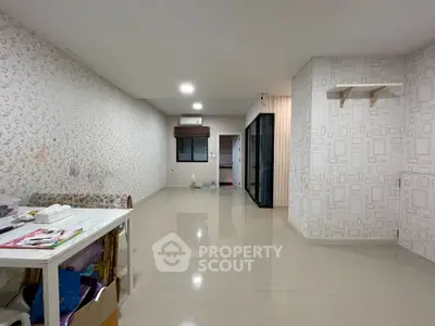 Spacious unfurnished living room with tiled flooring and patterned wallpaper