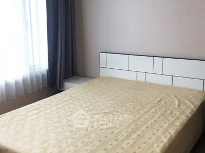 Cozy bedroom with large window and modern headboard, perfect for natural light lovers.