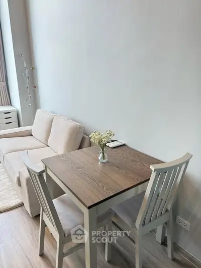 Cozy living room with a modern sofa and dining table, perfect for small apartments.