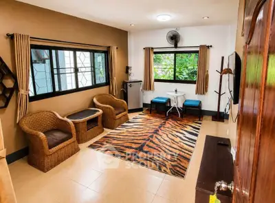 Charming living room with cozy wicker chairs and vibrant tiger rug, perfect for relaxation and entertaining.