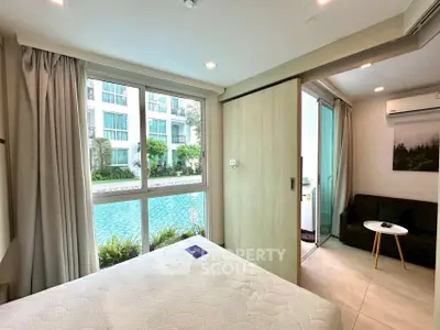 Modern bedroom with pool view and sliding glass doors to balcony.