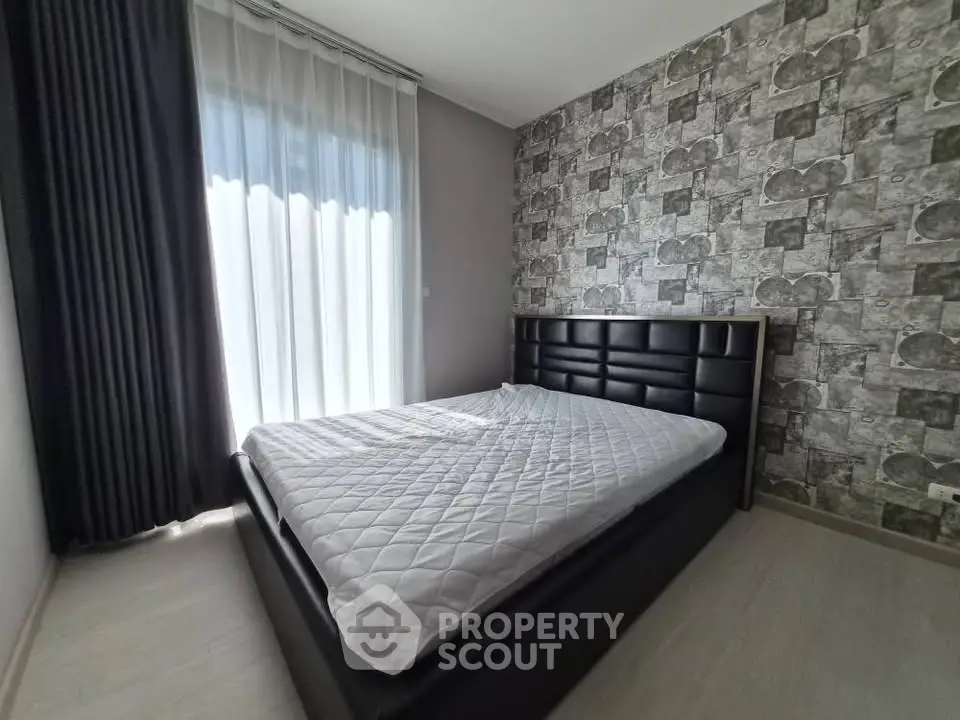 Modern bedroom with stylish wallpaper and elegant curtains, featuring a comfortable bed and natural light.