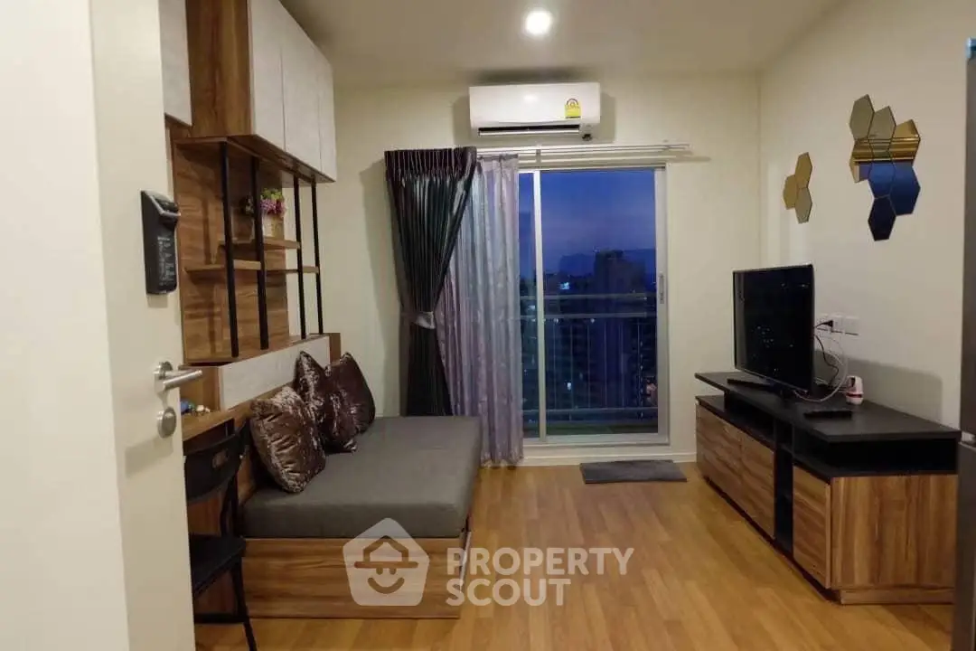 Modern living room with wooden flooring, stylish decor, and city view balcony.