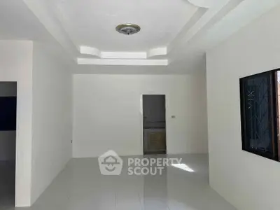 Spacious unfurnished room with modern ceiling design and natural light.