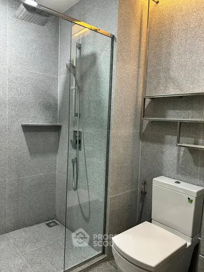 Modern bathroom with sleek shower and toilet in a stylish real estate property.