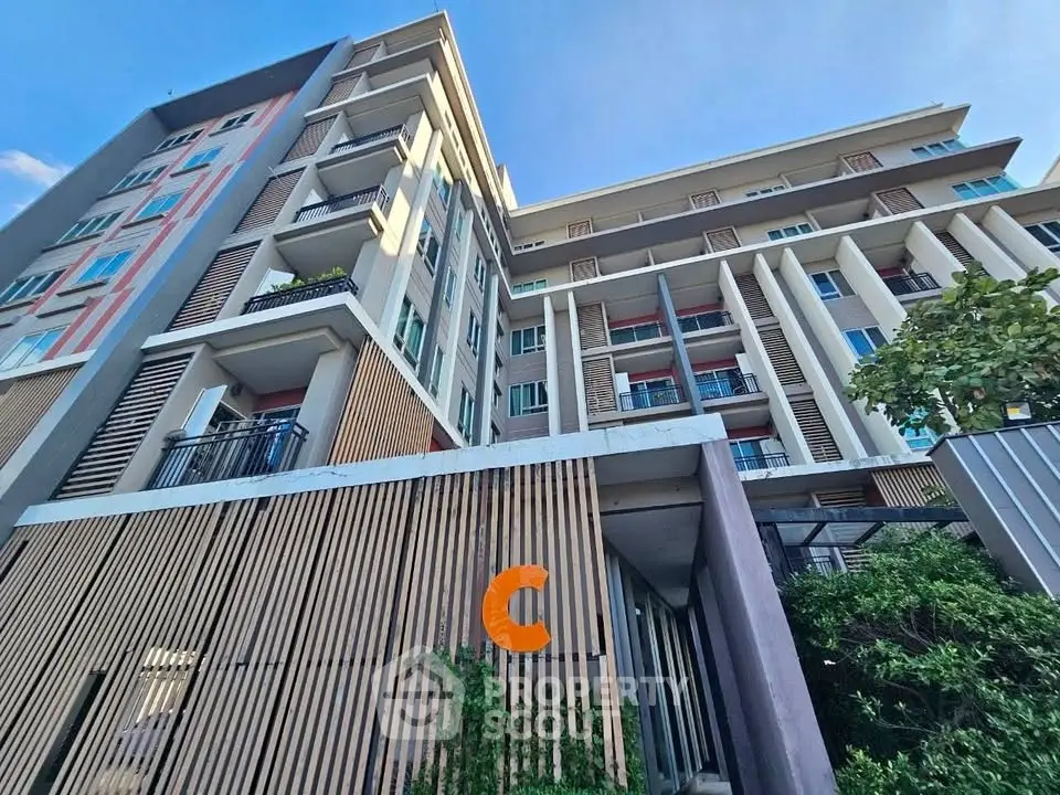 Modern multi-story residential building with balconies and contemporary design.