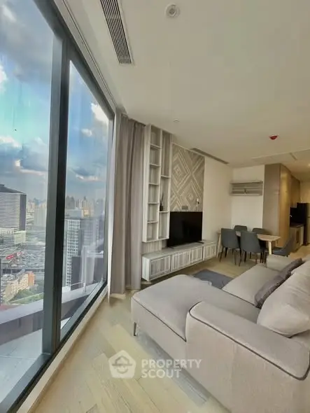 Luxurious modern living room with panoramic city view, featuring elegant decor and spacious seating area.