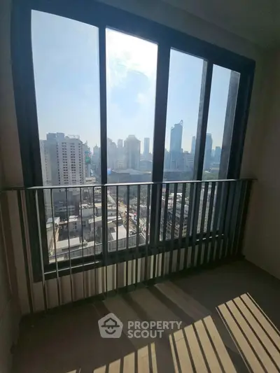 Stunning cityscape view from a high-rise balcony with floor-to-ceiling windows.