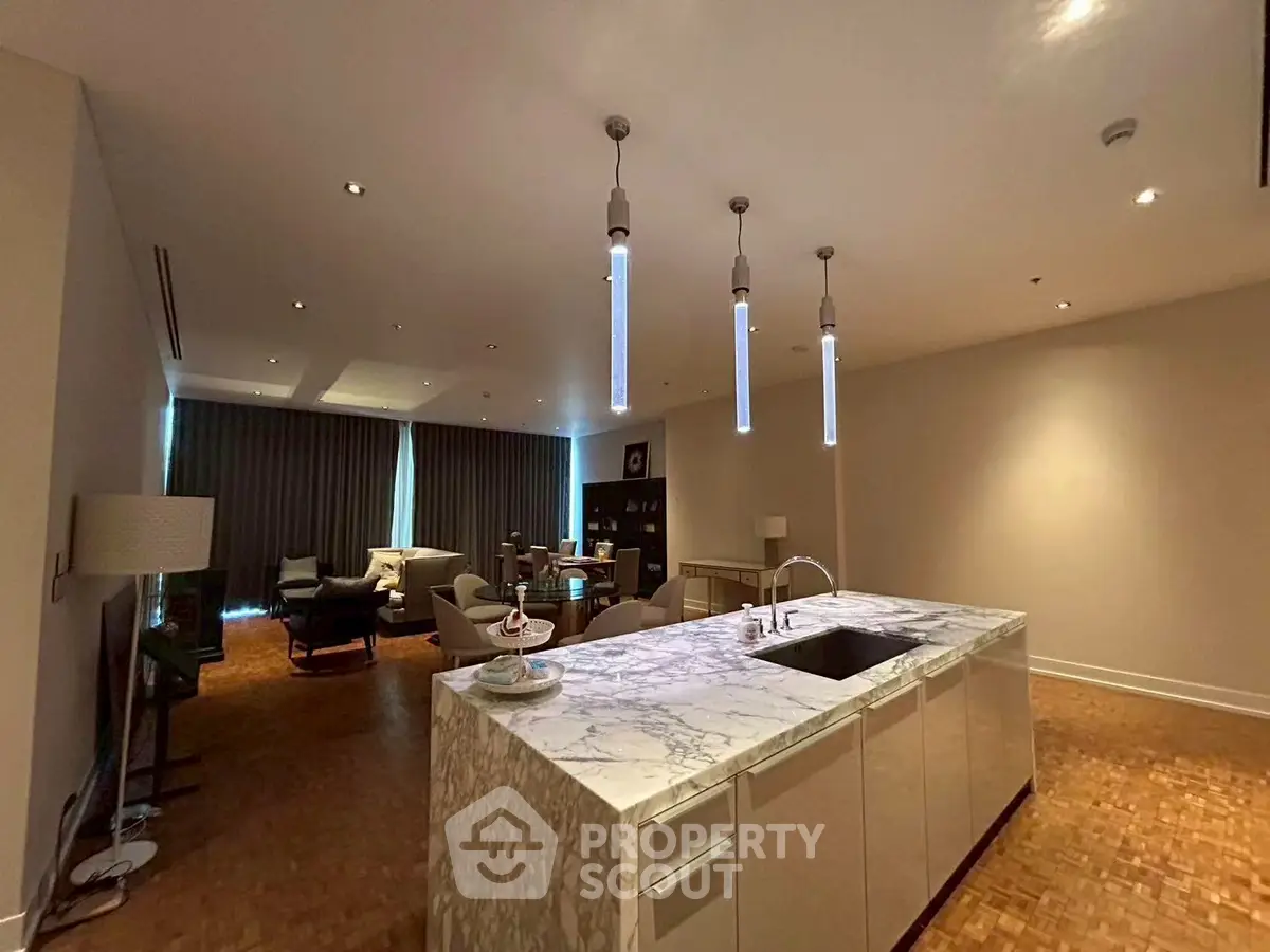 Luxurious open-plan living room with modern kitchen island and elegant lighting.