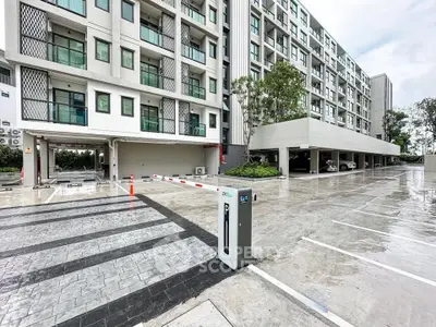 Modern apartment building with spacious parking area and sleek design.