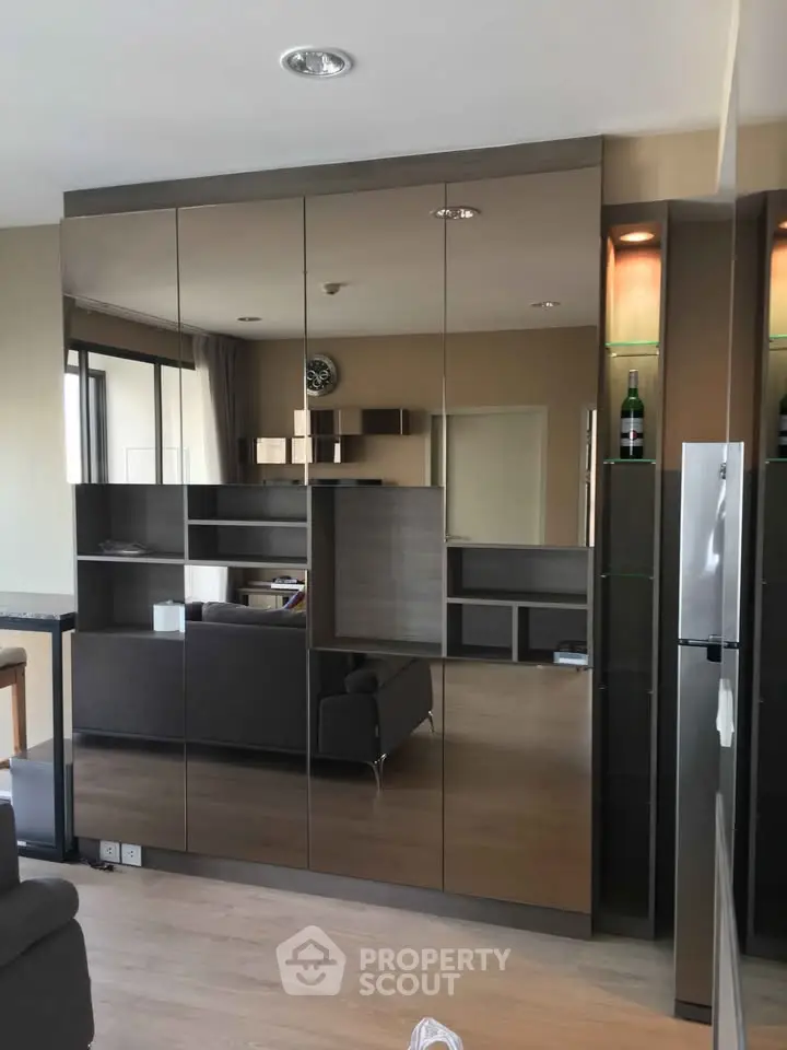 Modern living room with sleek mirrored cabinets and stylish shelving