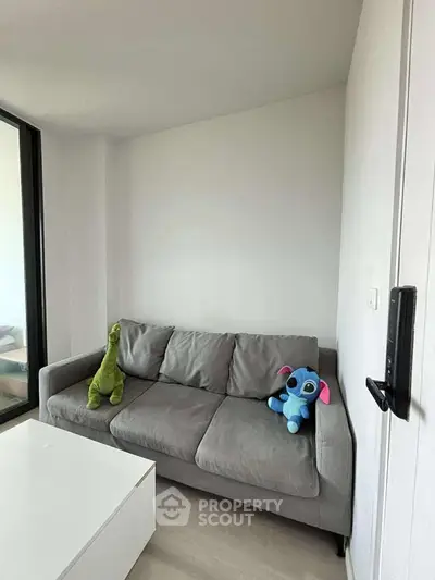Cozy living room with plush sofa and playful stuffed toys, perfect for relaxation and family time.