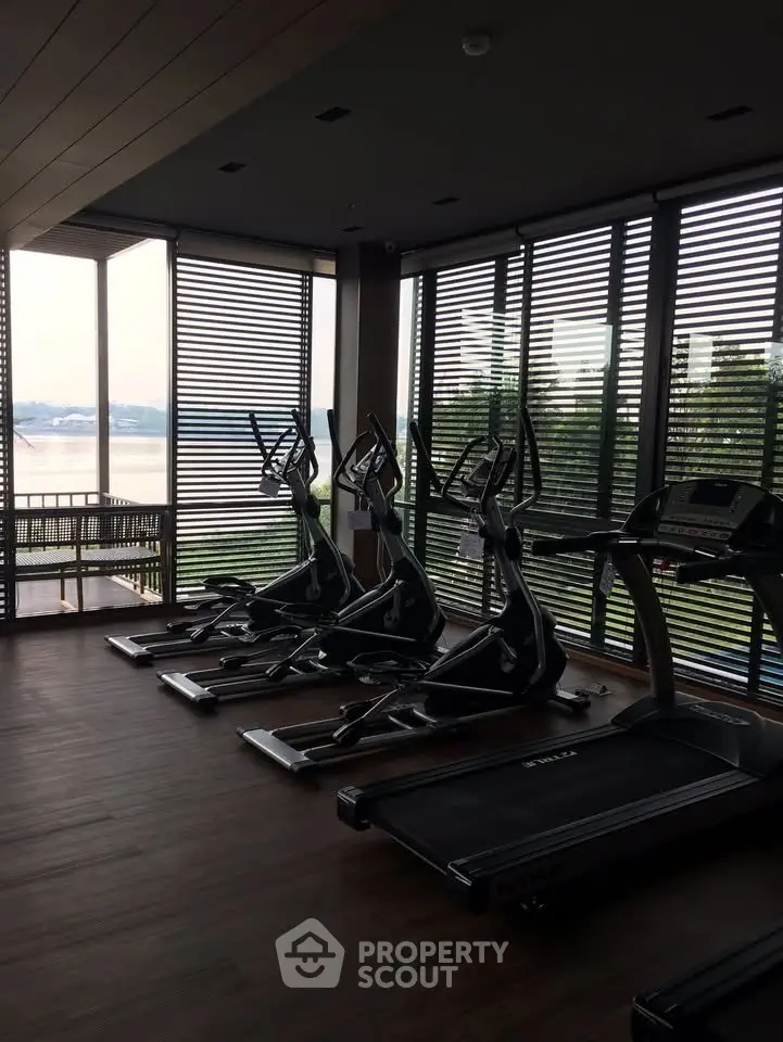 Modern gym with exercise equipment and scenic view through large windows