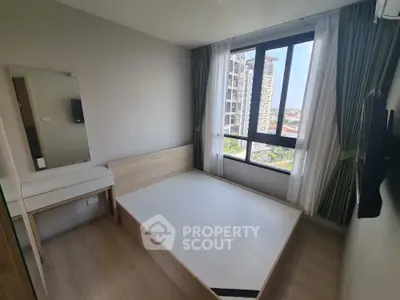 Modern bedroom with large window and city view in high-rise apartment