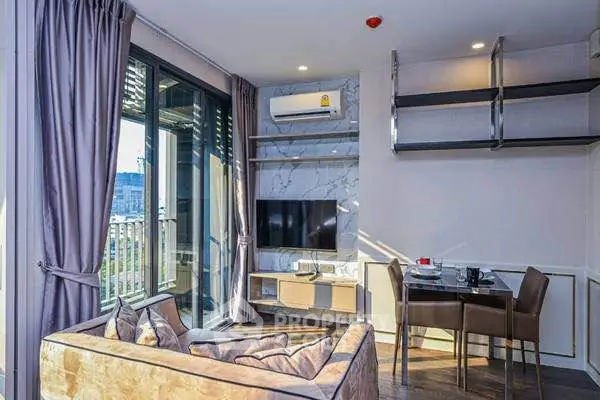 Modern living room with balcony, featuring stylish decor and natural light.