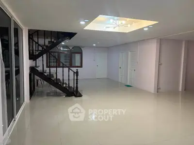 Spacious open-plan living area with modern staircase and elegant lighting