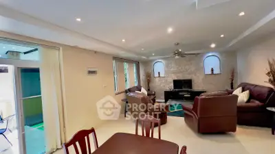Spacious living room with leather sofas and modern decor, perfect for relaxation and entertainment.