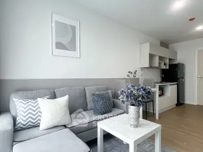 Modern living room with stylish decor and compact kitchen area.