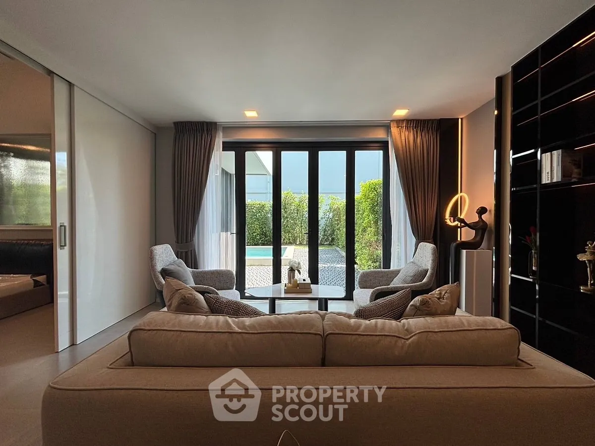 Luxurious living room with modern decor and garden view, featuring elegant furniture and ample natural light.