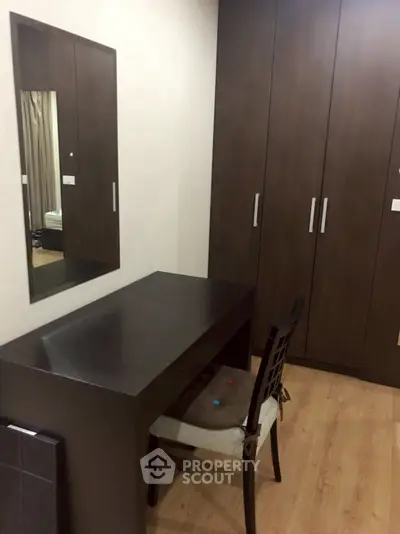 Modern bedroom with sleek dark wood furniture and spacious wardrobe