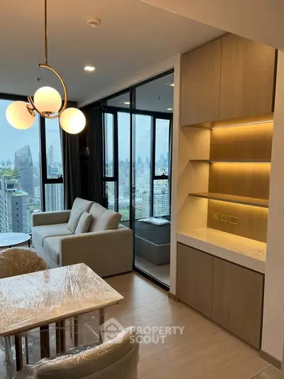 Modern living room with city view, featuring elegant lighting and stylish furniture in a high-rise apartment.